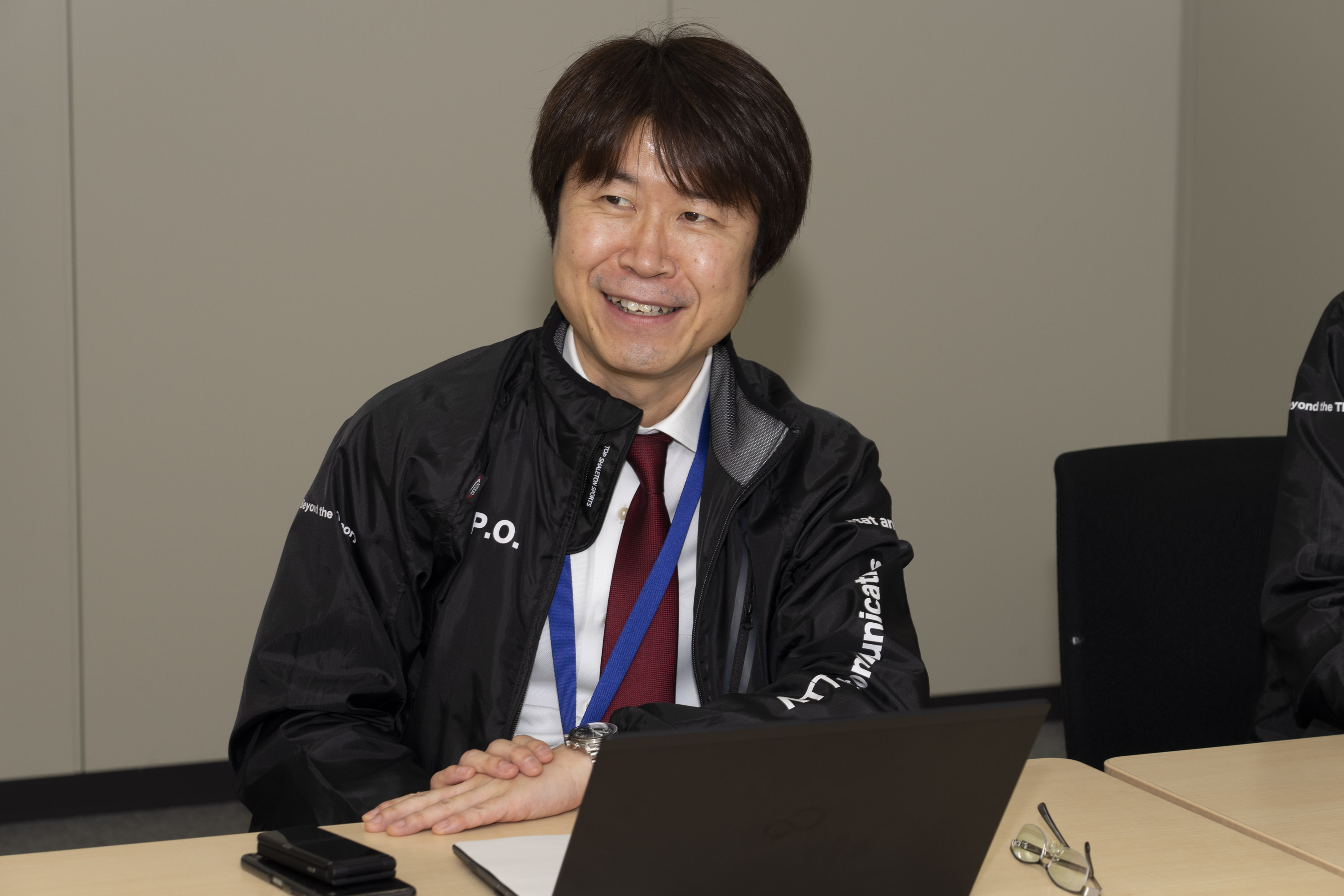 深村室長が笑顔でインタビューを受ける様子の写真