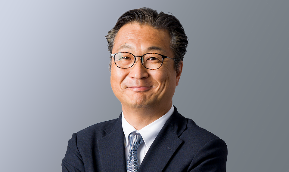 取締役/営業本部 HCソリューション営業部担当　村上 宜洋が笑顔で撮影されている写真