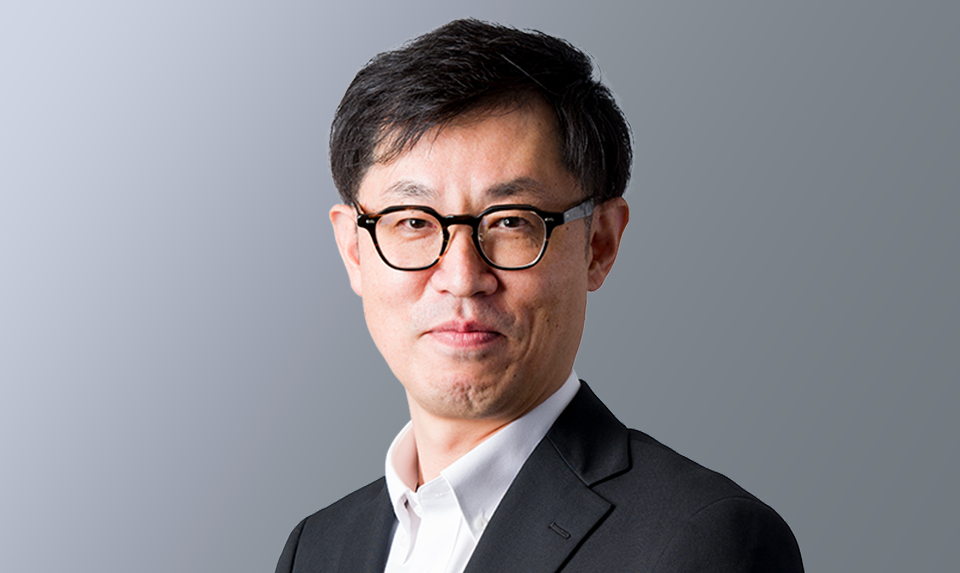 取締役/年金・健康保険部長　越智 章が笑顔で撮影されている写真